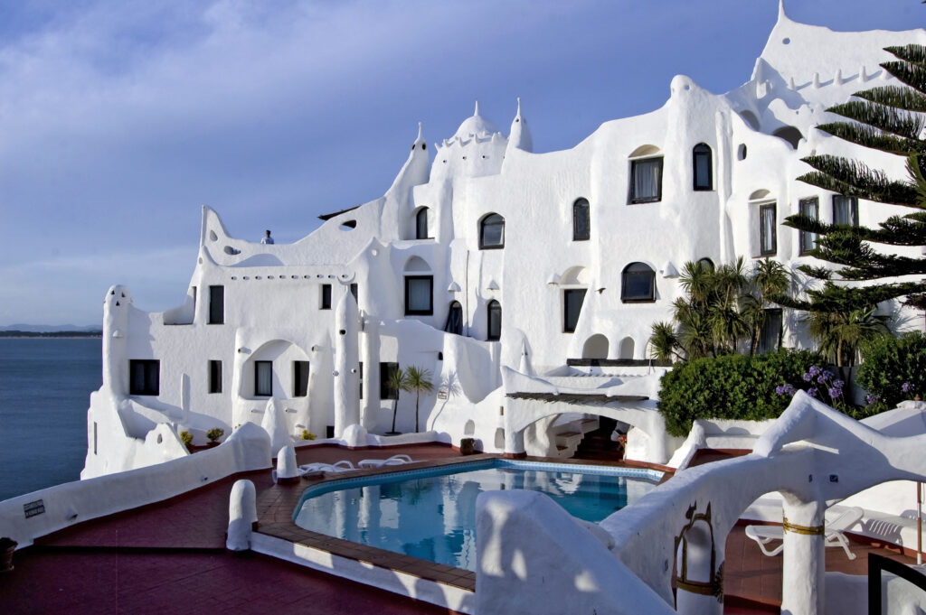 Arquitetura orgânica branca da Casapueblo com piscina e vista para o mar em Punta Ballena, atração imperdível de roteiro no Uruguai.