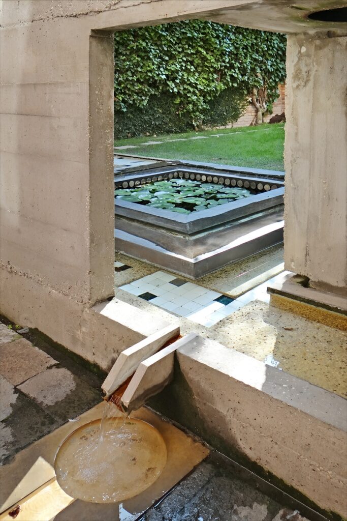 Fonte com bica de pedra da Ístria e espelho d'água com ninfeias no jardim da Fondazione Querini Stampalia, projeto de Carlo Scarpa.