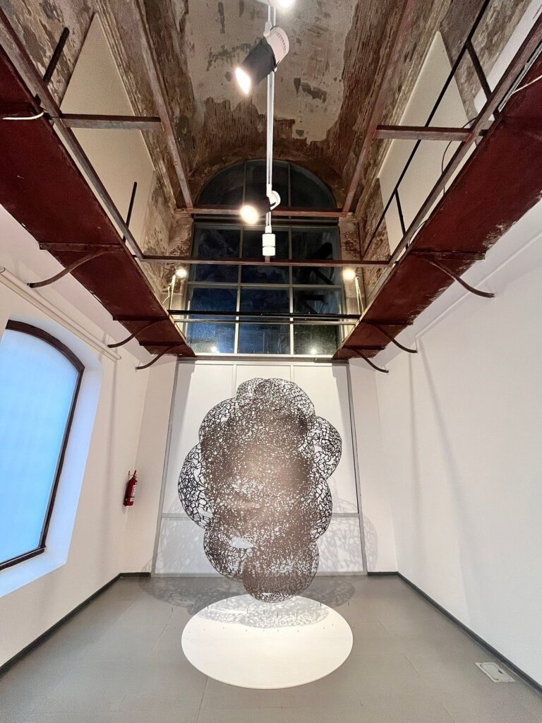 Galeria de arte contemporânea no antigo presídio Miguelete com pé-direito alto e escultura suspensa, dica cultural de roteiro no Uruguai.
