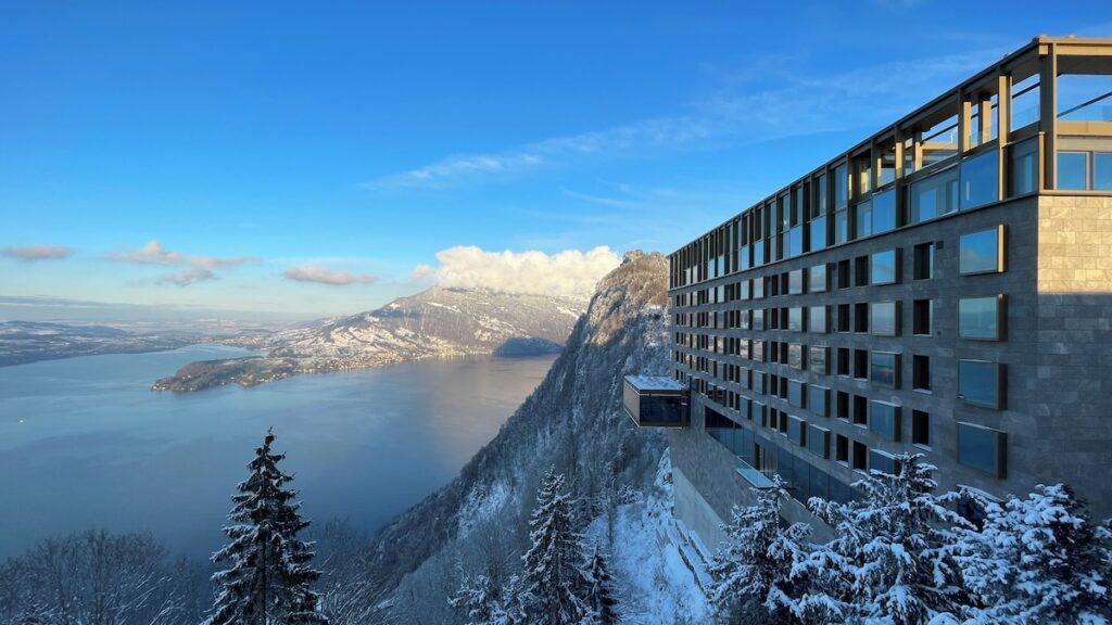 Fachada contemporânea em pedra do Bürgenstock Hotel sobre o Lago de Lucerna, ícone entre os hotéis de luxo nos Alpes suíços.