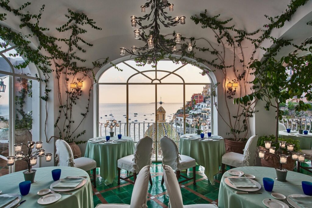 Salão em arcos com vista para Positano no La Sponda, dos restaurantes mais bonitos da Itália.