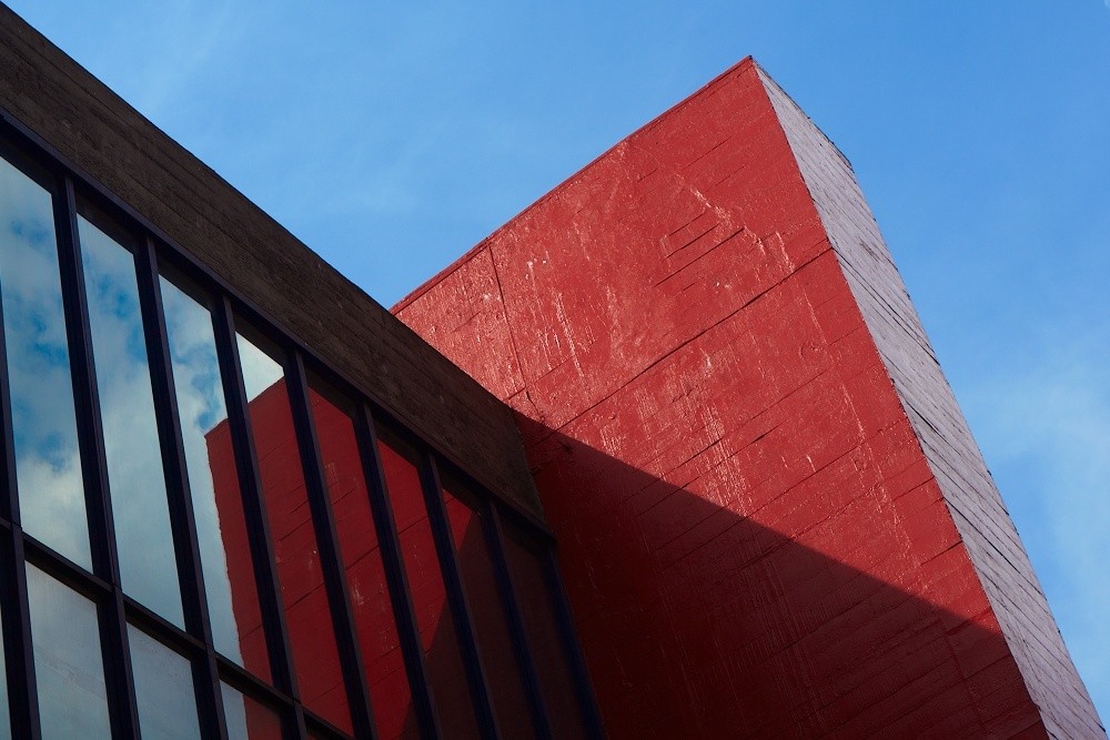 Detalhe do pilar vermelho e fachada envidraçada do MASP, ícone monumental do brutalismo em São Paulo.
