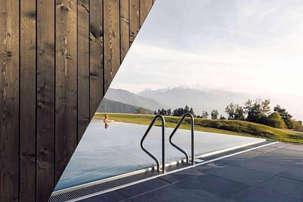 Piscina de borda infinita e fachada em madeira no Hotel Milla Montis, ícone de arquitetura nos hotéis de luxo nos Alpes.