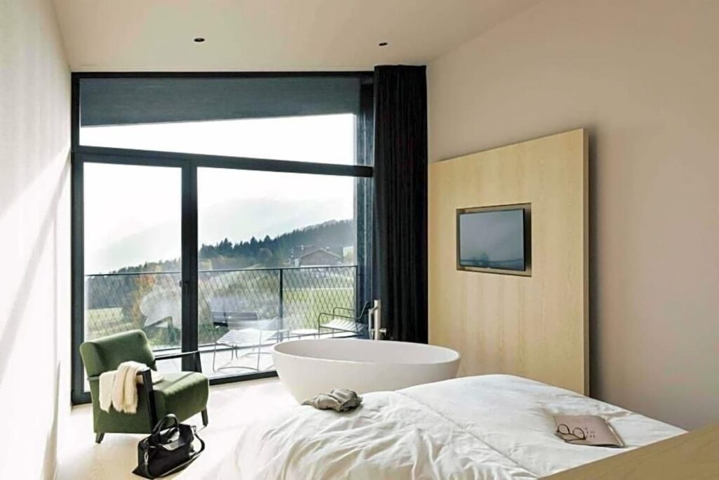 Quarto com vista panorâmica e banheira no Hotel Milla Montis por Peter Pichler, entre os hotéis de luxo nos Alpes.
