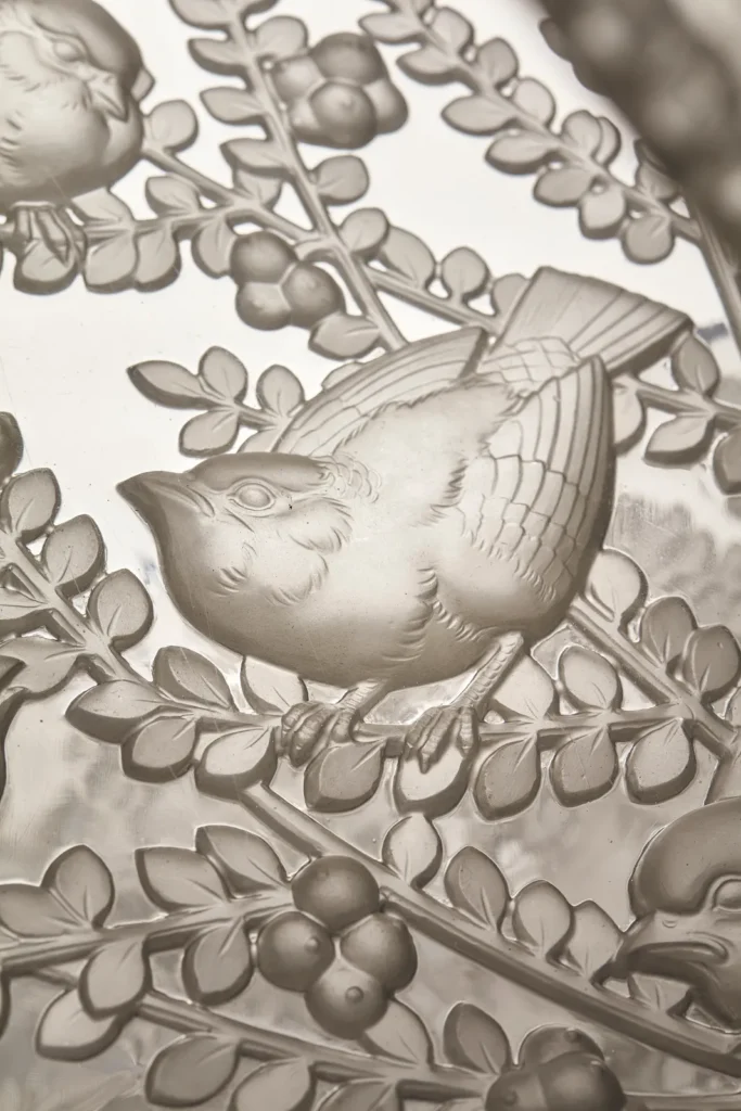 Macro da escultura de pássaro em vidro prensado no lustre de René Lalique, modelo Alger 1.