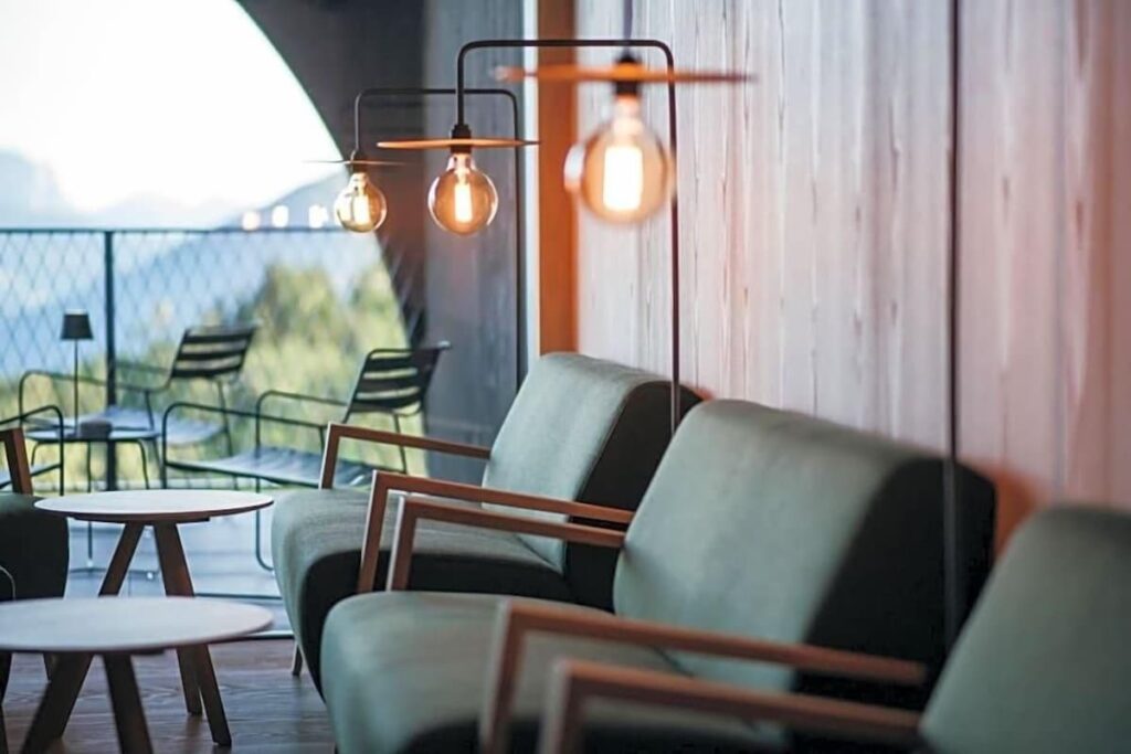 Lounge e saguão com painéis de lariço e design alpino no Hotel Milla Montis, exclusivo em hotéis de luxo nos Alpes.