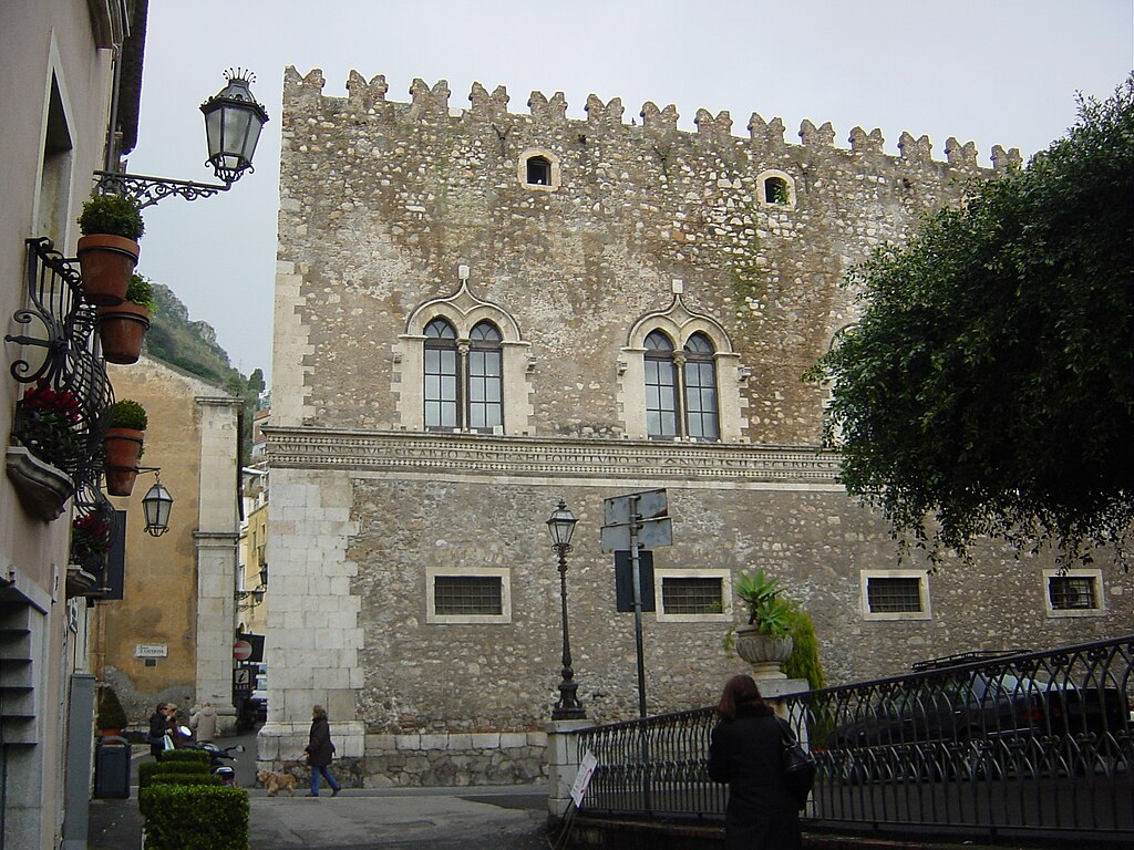 Taormina na Itália: Palazzo Corvaja com fachada de pedra e janelas arqueadas.