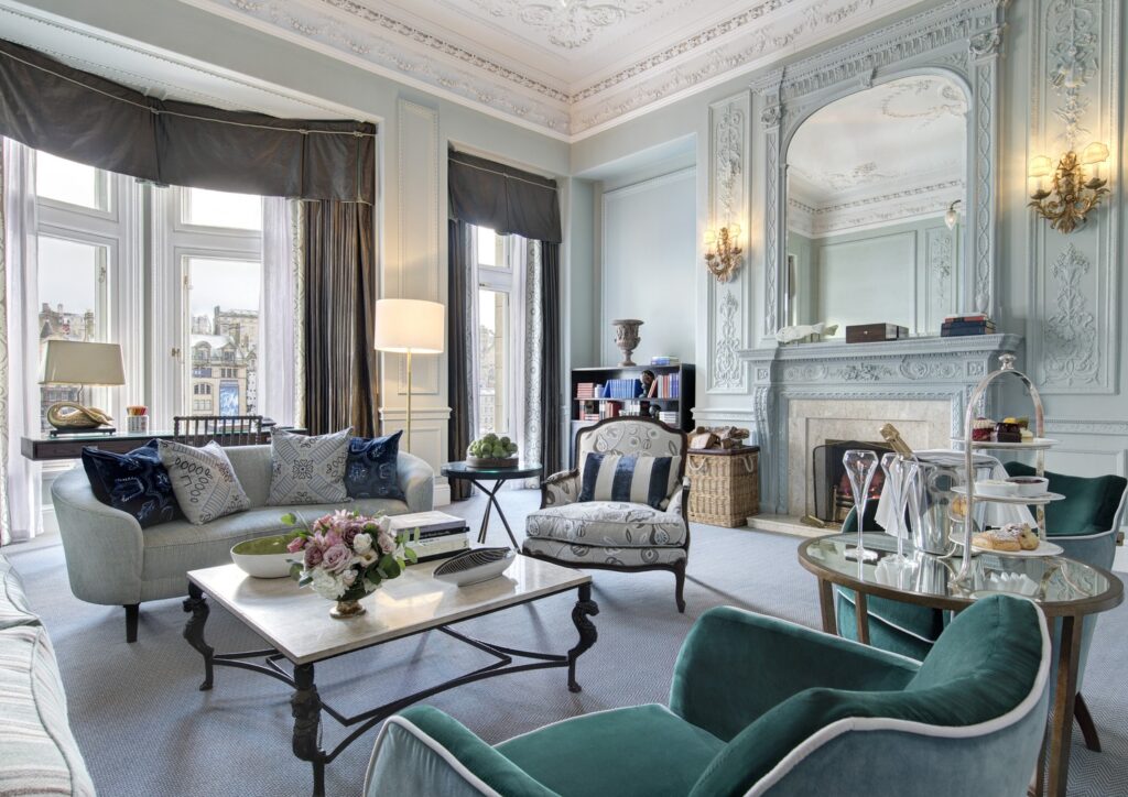 Elegante sala da Scone & Crombie Suite no Balmoral hotel com boiserie verde-água, lareira neoclássica e poltronas em veludo esmeralda.