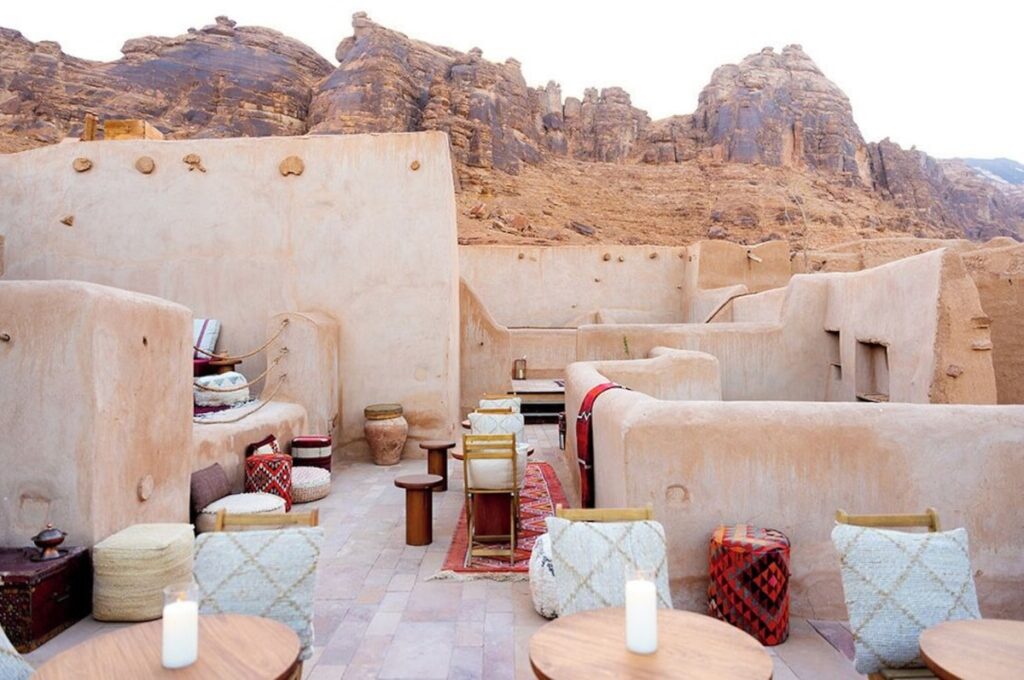 Terraço ao ar livre com vista para as montanhas rochosas em hotel no deserto de AlUla.