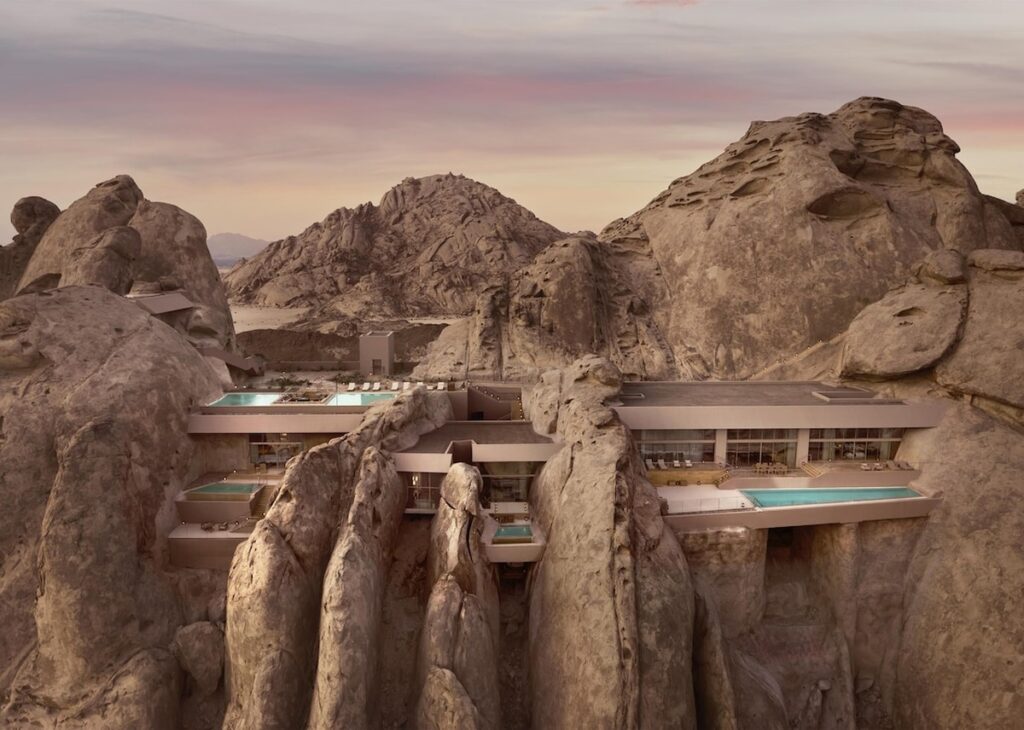 Arquitetura escavada na rocha com piscinas privativas suspensas no Desert Rock Hotel.