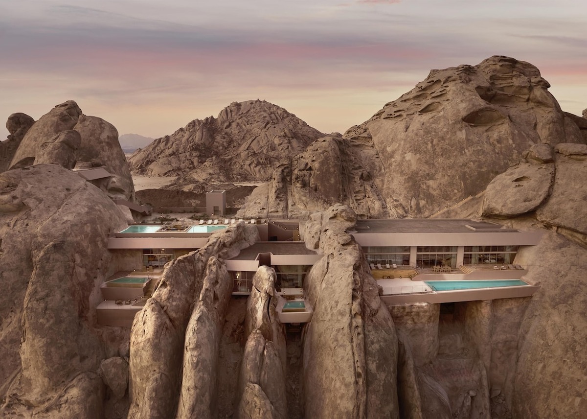 Arquitetura escavada na rocha com piscinas privativas suspensas no Desert Rock Hotel.