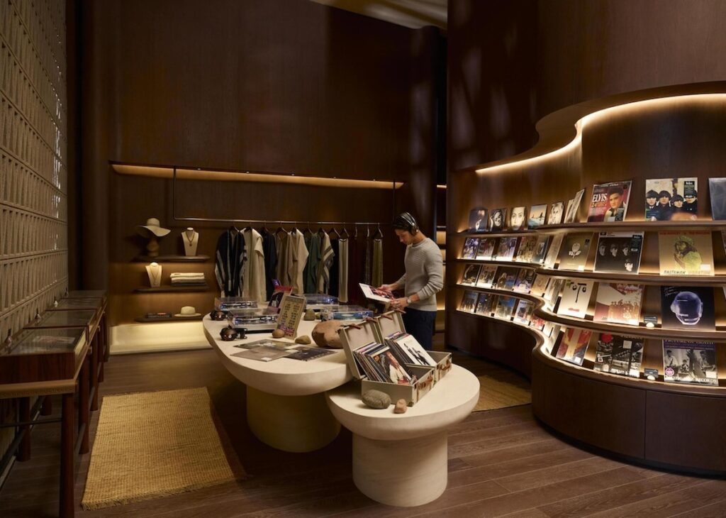 Listening Room com estantes curvas de vinil e mesas de pedra no Desert Rock Hotel.