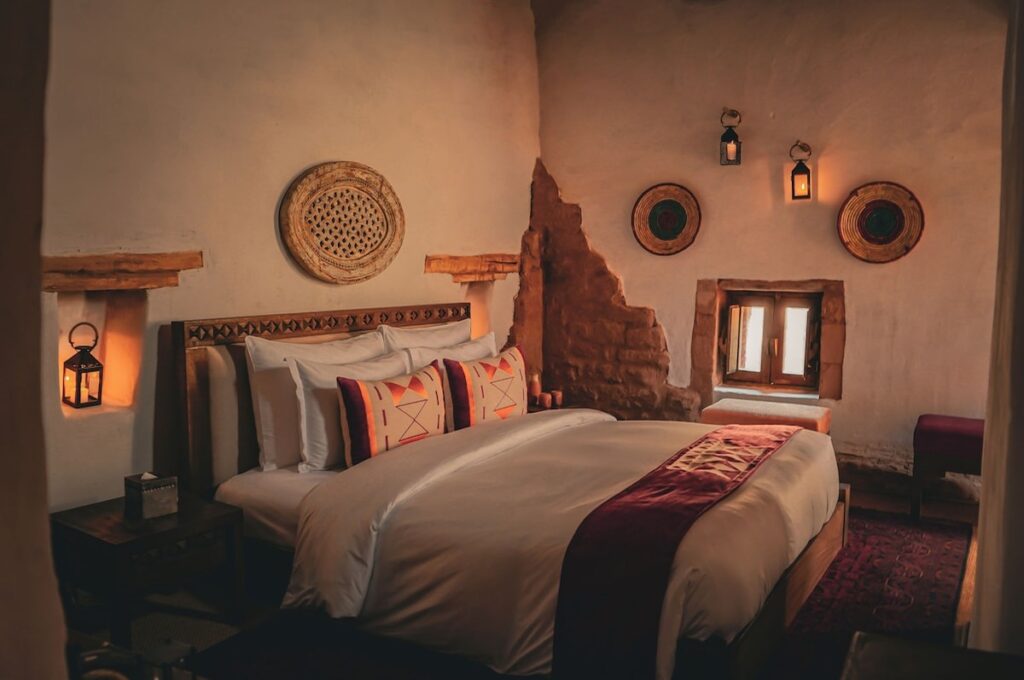 Quarto com parede de adobe aparente e cestarias artesanais no Dar Tantora.