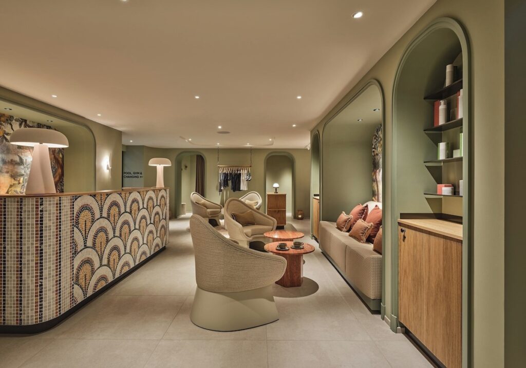 Lounge de relaxamento do spa no Balmoral hotel com balcão em mosaico escamado, paredes em verde suave e poltronas orgânicas giratórias.