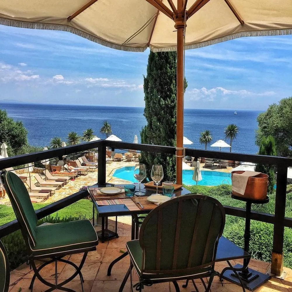 Mesa ao ar livre no terraço do Il Pellicano com vista panorâmica para o mar, ícone entre os restaurantes mais belos da Itália.