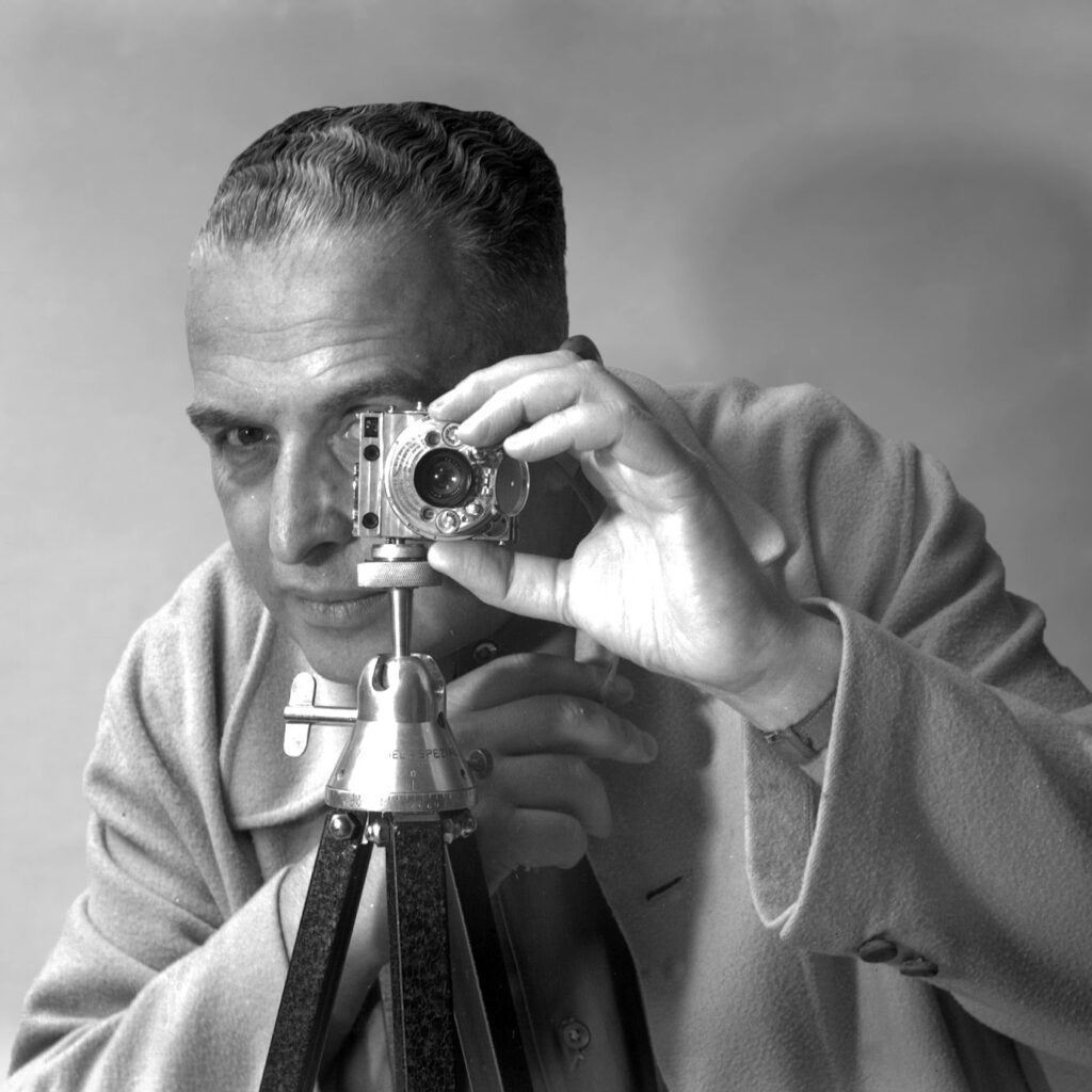 Retrato de Gregori Warchavchik com câmera, ícone do modernismo em São Paulo e pioneiro da arquitetura moderna.