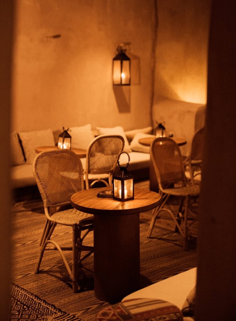 Ambiente intimista com cadeiras de palha trançada e lanternas em hotel no deserto de AlUla.