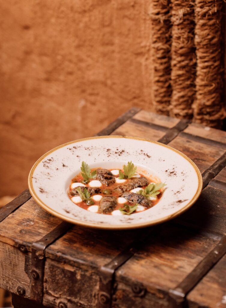 Gastronomia árabe contemporânea servida sobre baú rústico em hotel no deserto de AlUla.