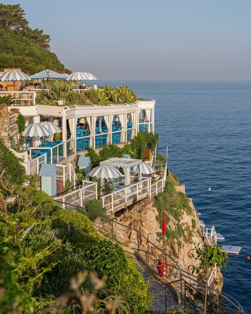 Vista arquitetônica do restaurante Il Riccio nas falésias de Capri, ícone absoluto entre os restaurantes mais belos da Itália.