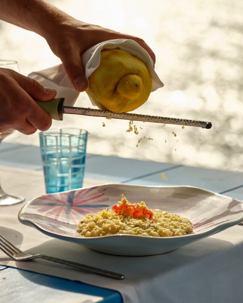 Finalização de risotto com limão-siciliano e gambero rosso no Il Riccio, referência entre os restaurantes mais belos da Itália.