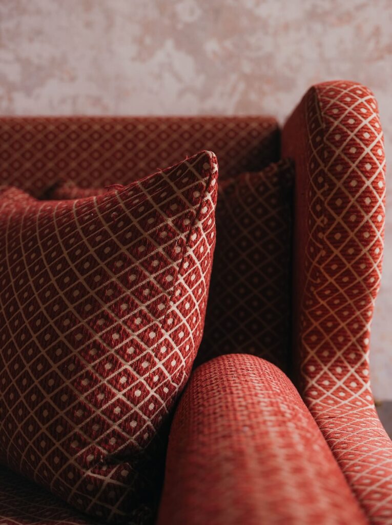 Detalhe de estofamento em jacquard geométrico terracota em poltrona do hotel G-Rough Roma.
