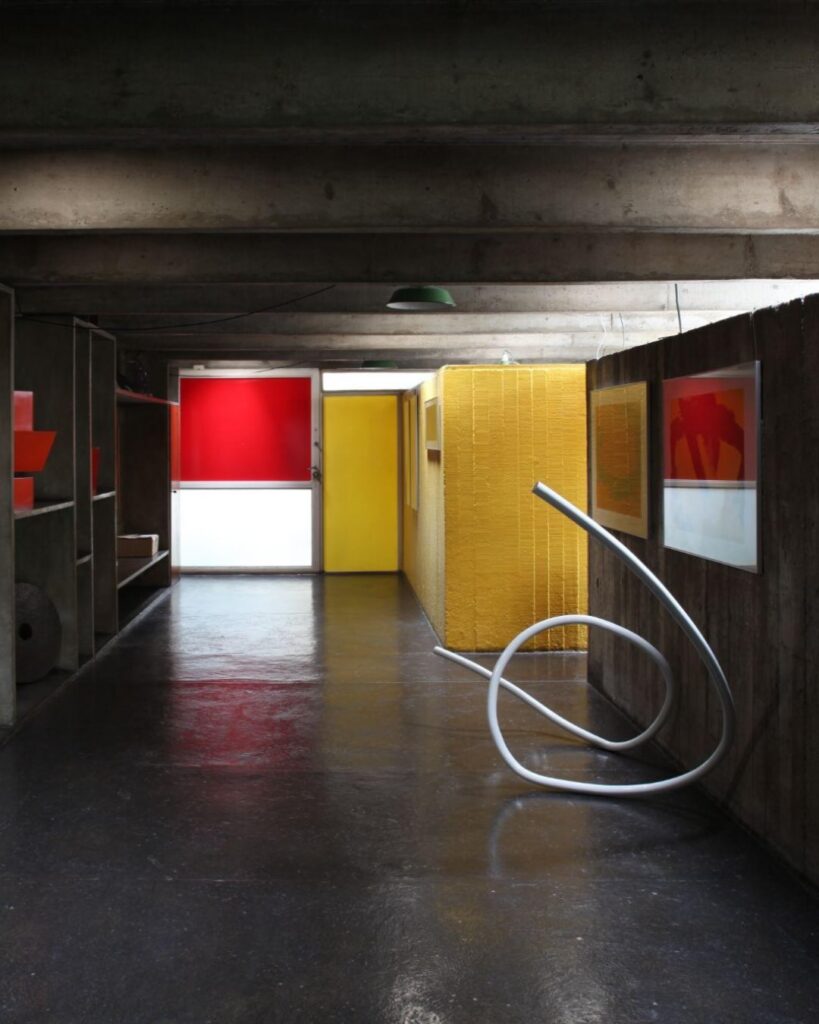 Corredor expositivo com painéis coloridos e escultura na Casa Ateliê Tomie Ohtake, museu pequeno em são paulo com obras modernistas.