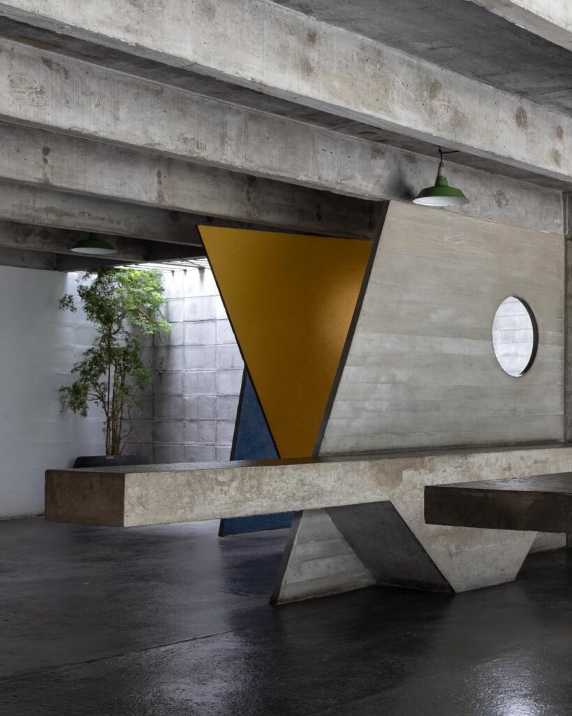 Vigas de concreto, planos amarelos e óculo na Casa Ateliê Tomie Ohtake, museu pequeno em são paulo focado em arte e arquitetura.
