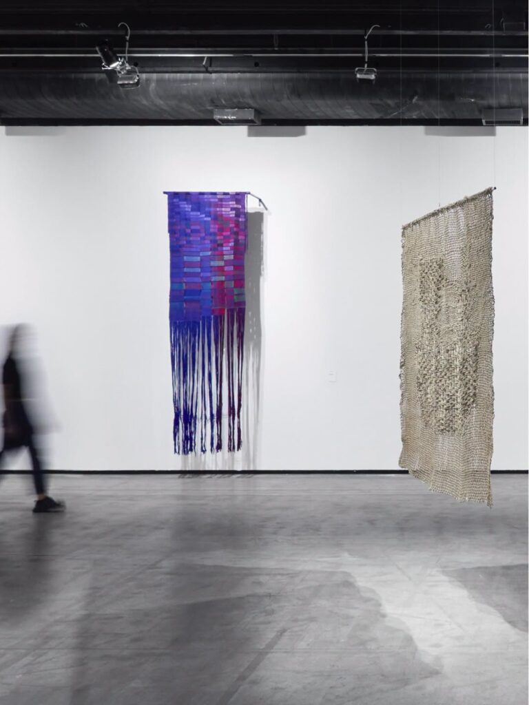 Obras têxteis de Sheila Hicks no Instituto Tomie Ohtake, destaque na rota de museus em São Paulo com galeria de pé-direito alto e piso de concreto.