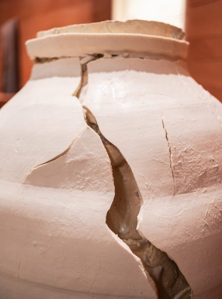 Macro de fenda expressiva em vaso cerâmico branco texturizado, destaque de arte em exposições em São Paulo na Japan House.