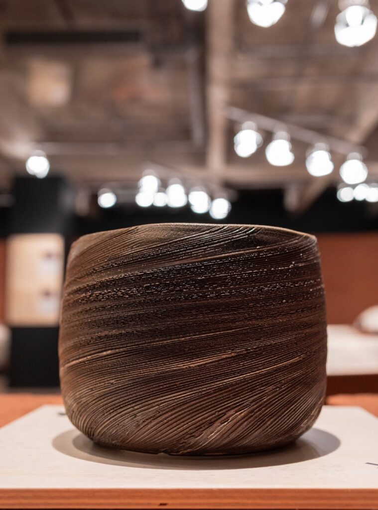 Tigela cerâmica texturizada com ranhuras artesanais exibida em exposições em são paulo na Japan House.