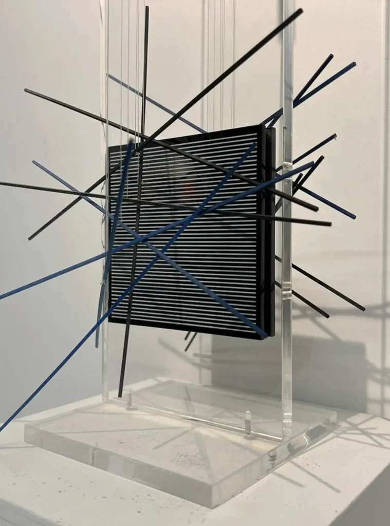 Escultura cinética de Jesus Soto em exposição em São Paulo com hastes suspensas, plano óptico e acrílico sobre base expográfica.