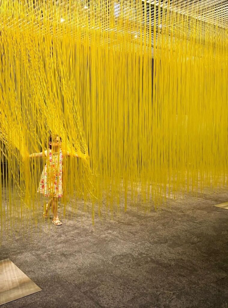 Interação imersiva no Penetrable amarelo de Jesus Soto em exposição em São Paulo unindo arte cinética, luz e textura tátil.