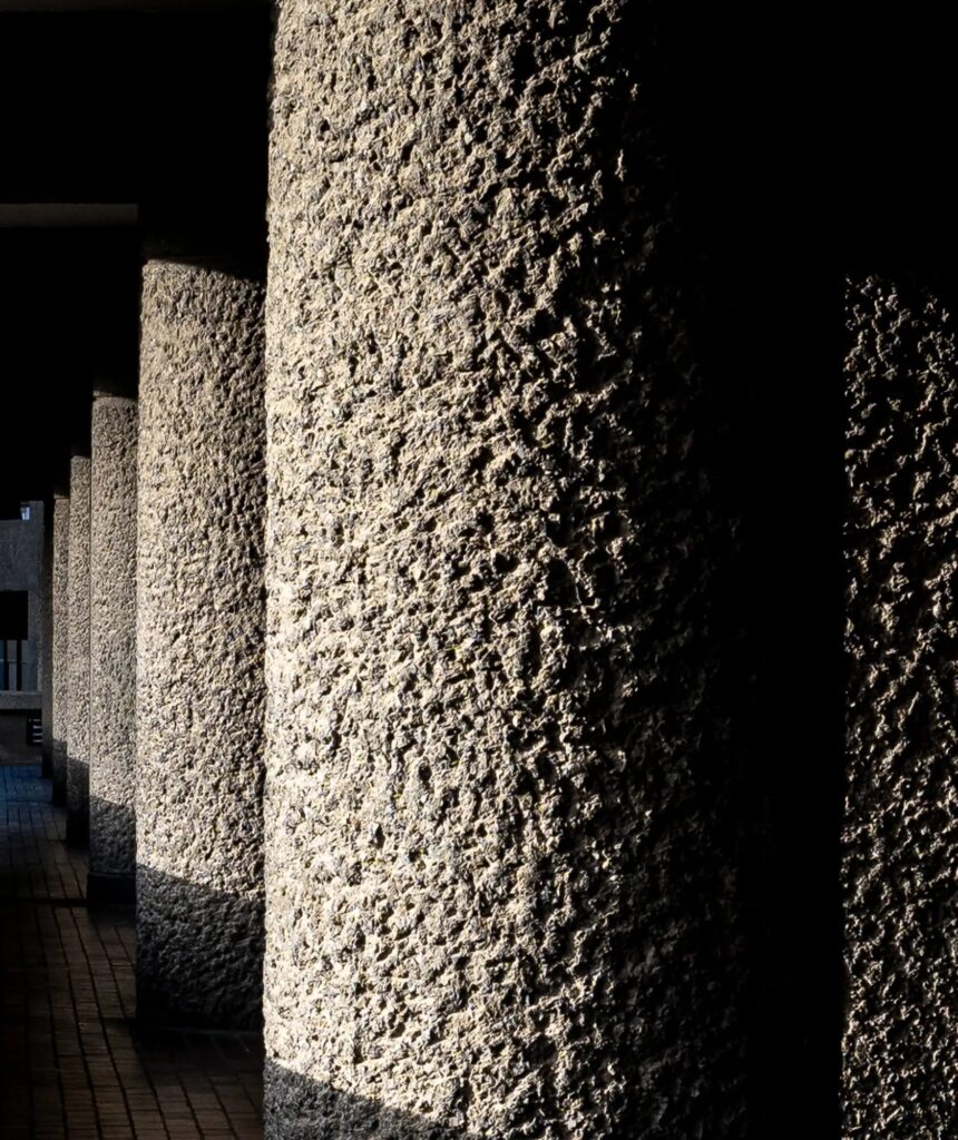 Pilotis cilíndricos de concreto apicoado no Barbican Estate em Londres, evidenciando as texturas táteis do movimento brutalista.