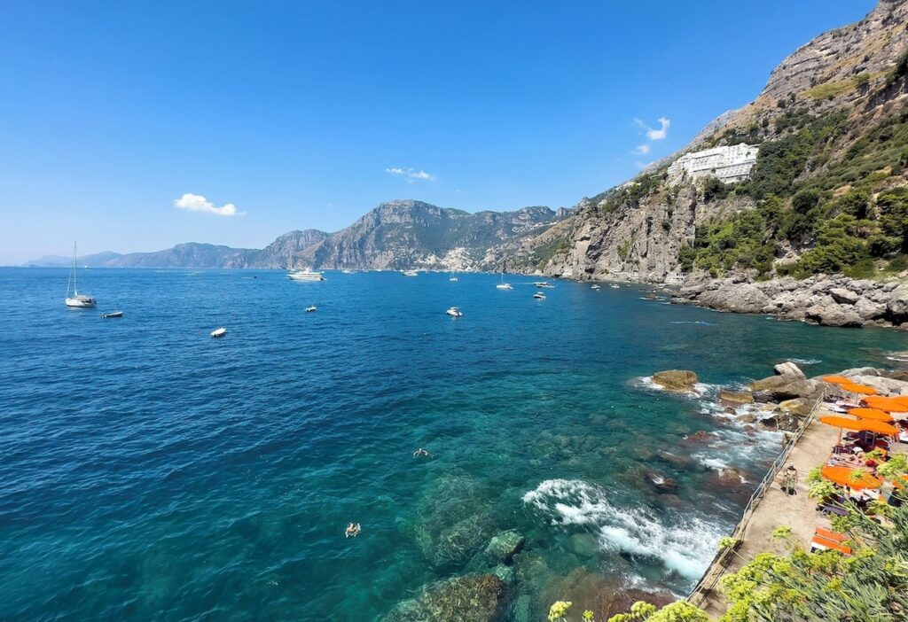 Vista panorâmica da encosta rochosa e mar azul ao redor do hotel Casa Angelina na Costa Amalfitana.