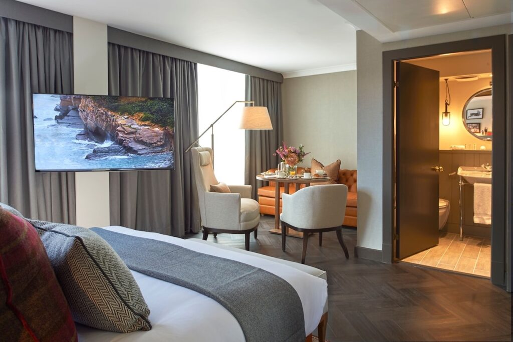 Quarto com recanto de café e vista para a sala de banho retrô no Kimpton Charlotte Square.