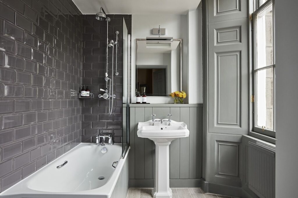 Banheiro de estilo vitoriano com banheira e azulejos bisotados no Kimpton Charlotte Square.