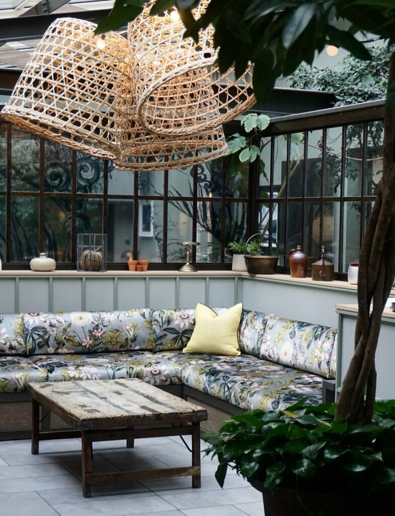 Lounge no jardim de inverno com sofá botânico e luminárias de fibra no Kimpton Charlotte Square.