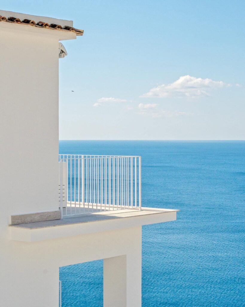 Detalhe de varanda arquitetônica em branco absoluto sobre o Mar Tirreno no hotel Casa Angelina.
