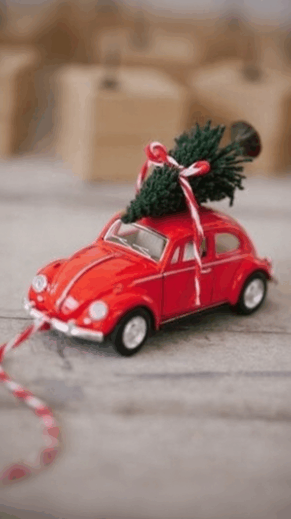 Carro de brinquedo vermelho com árvore de Natal no teto, decoração natalina tradicional